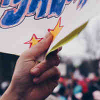 Close-up of hand holding sign in protest march