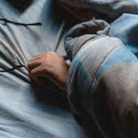 Image of arm and glasses in bed