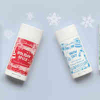 Schmidt's holiday deodorant line - Snow Day, Oh, Christmas Tree, and Holiday Spice laid out with snowflake background.