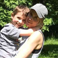 Jaime Schmidt holding her son in nature