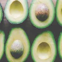 Image of assortment of sliced avocados, some with pits, some without