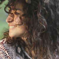 woman with curly hair looking off to the side