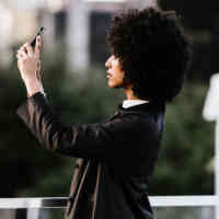 side profile of woman holding phone in the air taking photo