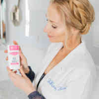 Dr. Whitney Bowe holding Rose + Vanille Schmidt's deo while wearing labcoat