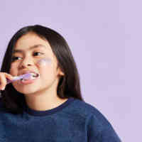 Adorable kid brushing teeth with Schmidt's Kids Toothpaste in Mint+Berry