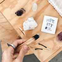 Girl holding palo santo wood with crystals