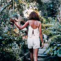 Girl walking through plants on a patio