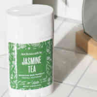 Schmidt's Jasmine Tea sensitive skin deodorant stick on a white tile countertop in front of a plant and a mirror
