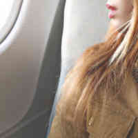 close up woman looking out plane window