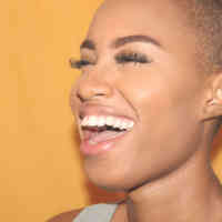woman smiling mouth open yellow background