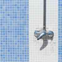 Douchewand met blauwe en witte tegels en kraanhandvatten