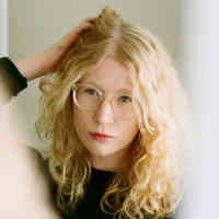 woman fluffing hair and looking in mirror